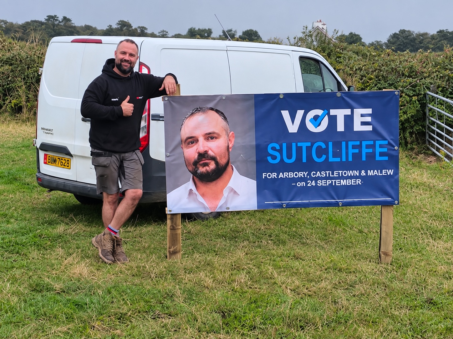 Geoff Sutcliffe standing beside his campaign sign and van